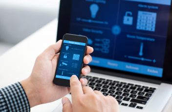 man holding phone with program smart home on the screen